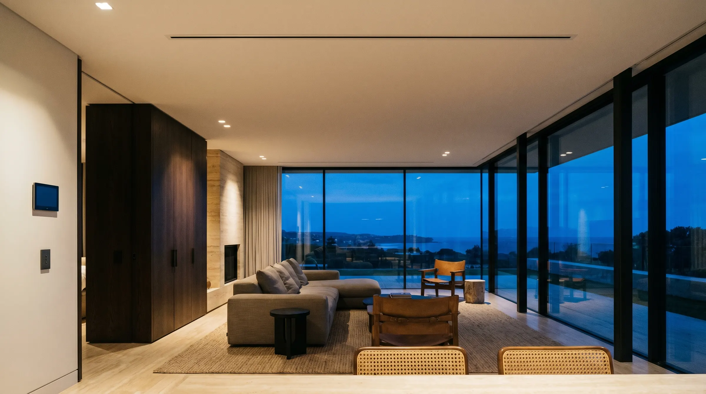 Luxury Canberra living room at dusk with concealed air conditioning — only a slim ceiling diffuser and a wall control panel show